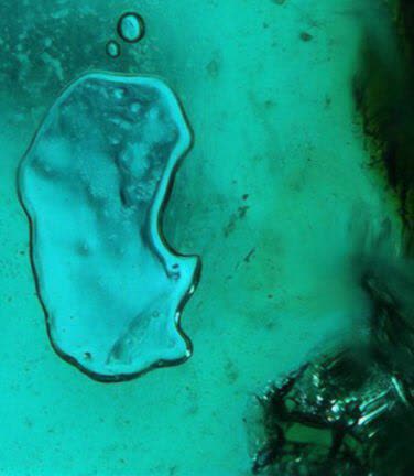 نمای نزدیکی از حباب‌ها در مرز بین سیمان سبز و پوشش کوارتز